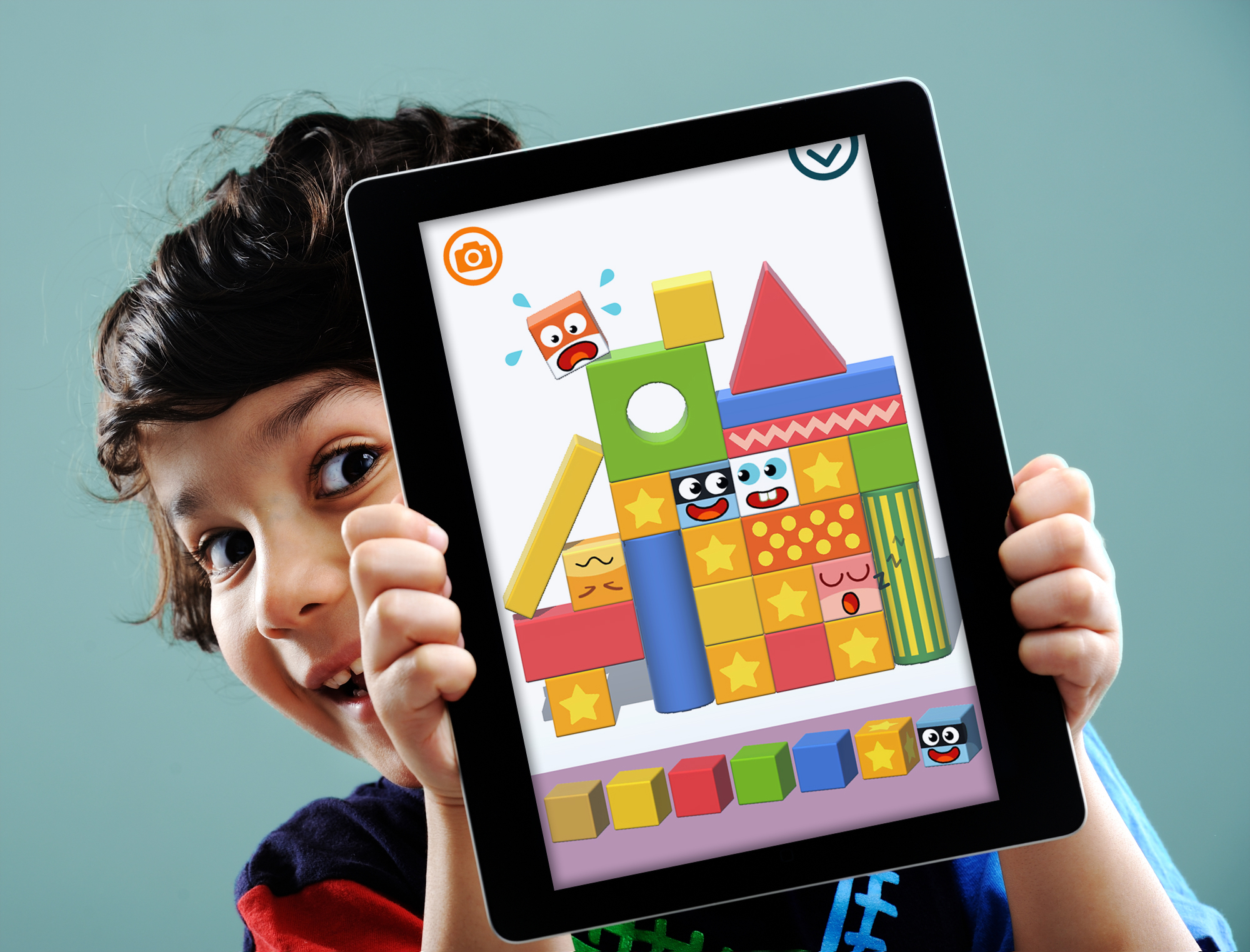 Un enfant présente sa construction Pango sur une tablette